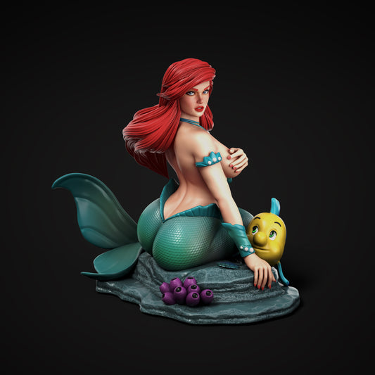 Ariel from Disney’s The Little Mermaid with her long red hair and green mermaid tail, alongside her best friend Flounder the tropical fish.