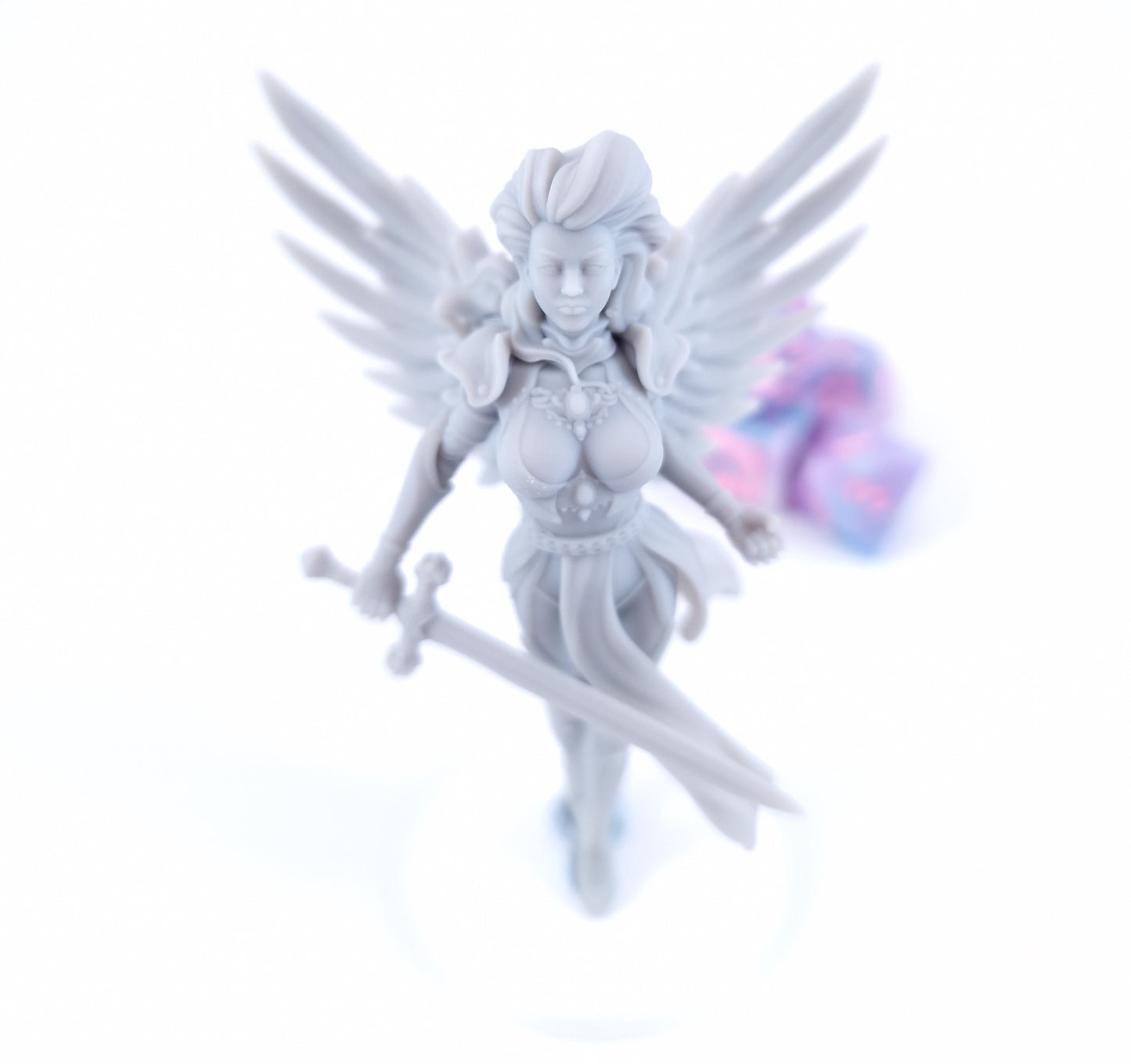 Aasimar Paladin miniature with large angelic white wings, ornate gold armor, flowing green and white tabard, red hair, and a longsword, posed on a display base.